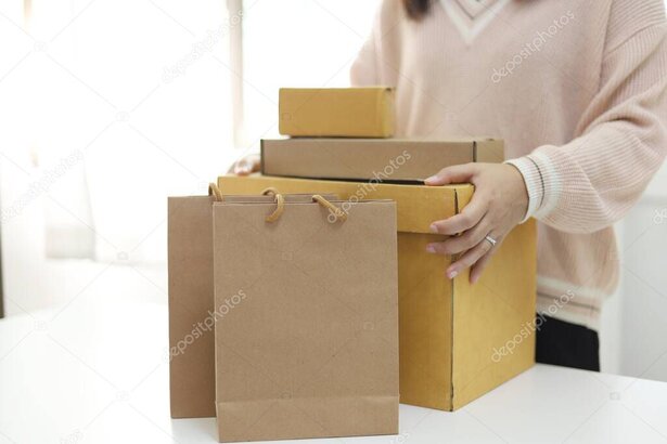 Mani che imballano un pacco con nastro adesivo pronto per la spedizione