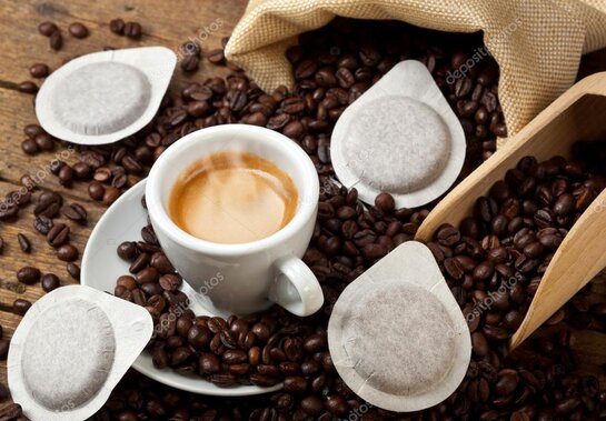 Cialde e capsule di caffè disposte vicino a una tazzina di espresso