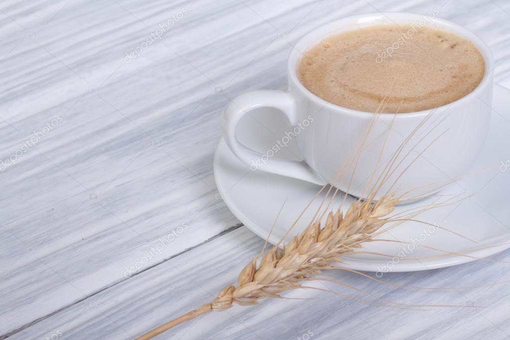Tazza di orzo fumante accanto a chicchi di cereali
