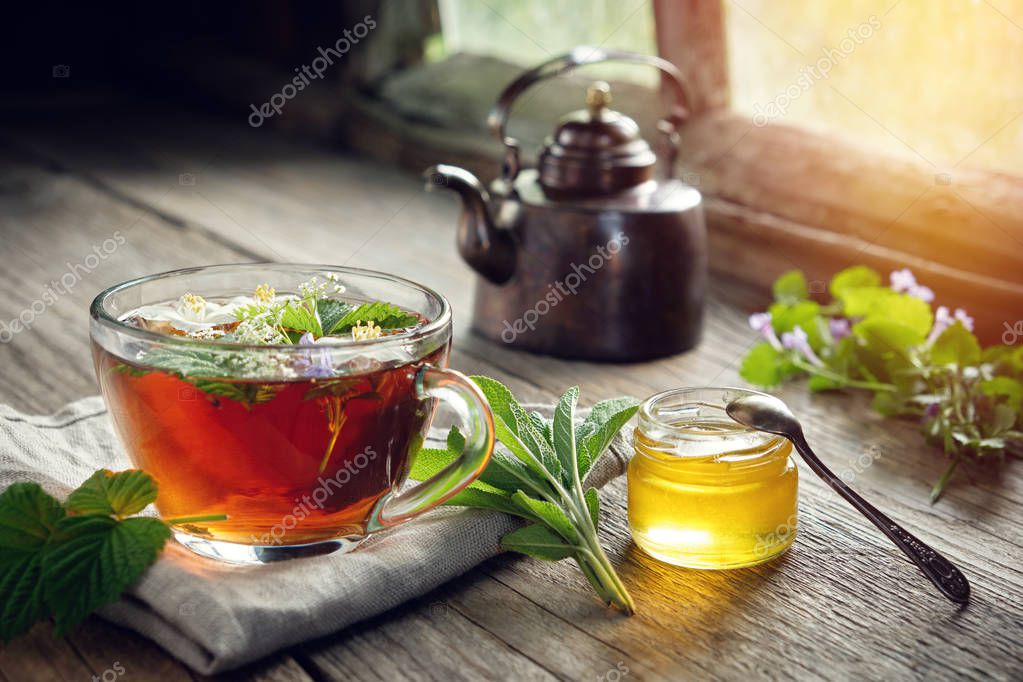 Tazza di tisana con erbe e fiori secchi sul tavolo