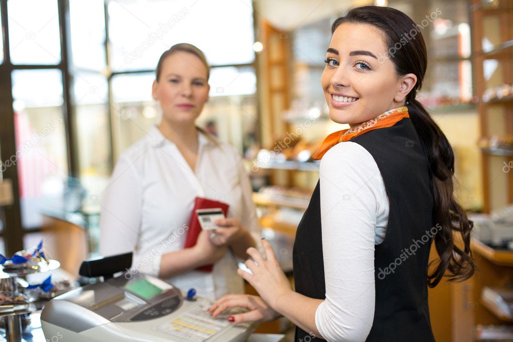 Addetta alla cassa che serve un cliente in tabaccheria