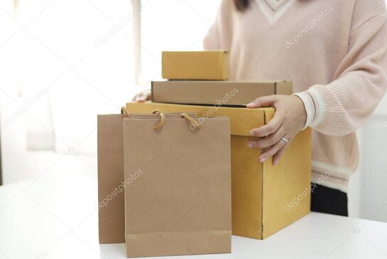 Mani che imballano un pacco con nastro adesivo pronto per la spedizione