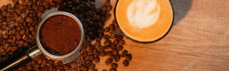 Tazzina di caffè con chicchi e capsule esposte su un bancone