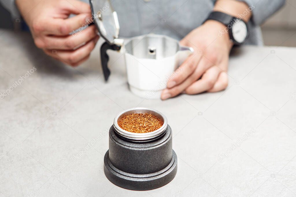 Caffettiera moka su un fornello con caffè macinato sul piano